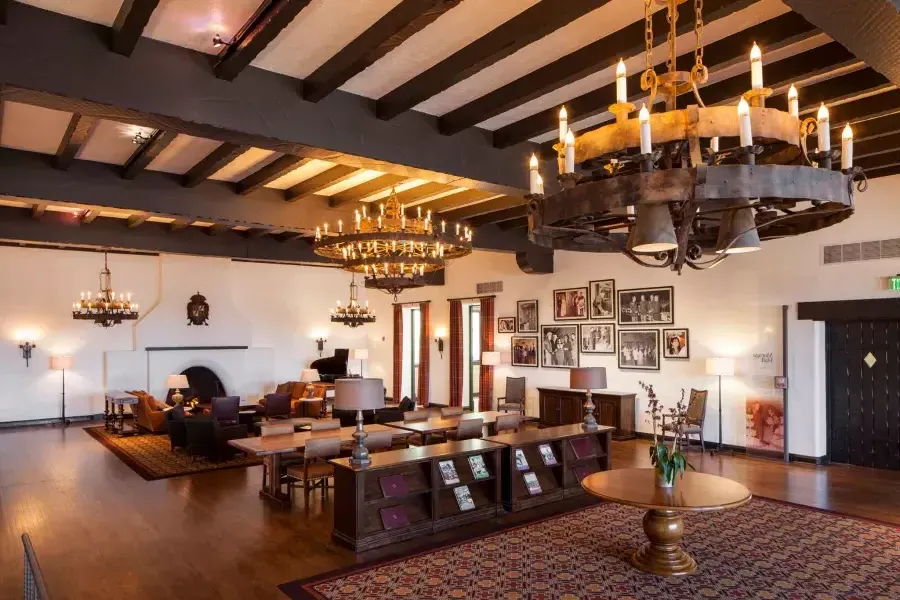 Intérieur du club historique des officiers du Presidio, avec plafonds aux poutres en bois et grands lustres.